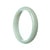 A half-moon shaped pale green jadeite bangle bracelet with a Grade A certification, measuring 57mm in diameter. Perfect for adding a touch of elegance to any outfit.