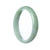 A close-up image of a pale green jadeite jade bangle bracelet with a half moon shape, certified as a natural gemstone. The bracelet measures 57mm in diameter and is adorned with the brand name "MAYS™".